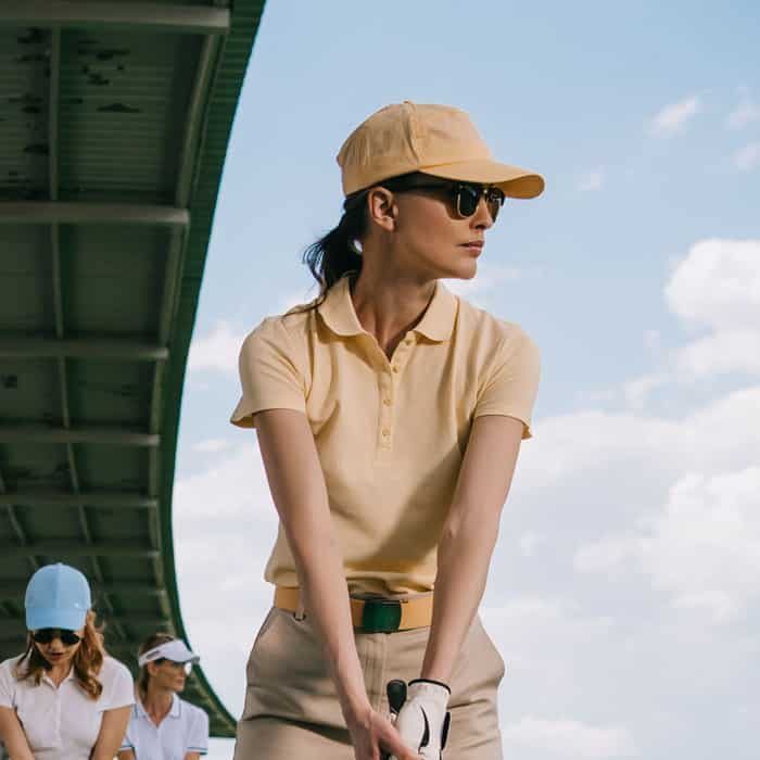 women-in-caps-with-golf-clubs-playing-golf-at-golf-8RWNJLN.jpg